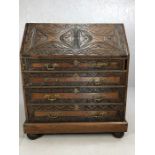 Heavily carved bureau with flight of four drawers and fall front opening to reveal pigeon holes,