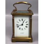 Circa 1900 brass repeating carriage clock with swing loop handle above white enamel dial set with