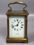 Circa 1900 brass repeating carriage clock with swing loop handle above white enamel dial set with
