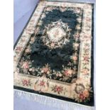 Soft green ground rug with floral design, approx 245cm x 153cm