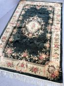Soft green ground rug with floral design, approx 245cm x 153cm