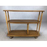 Light wood Ercol magazine/book trolley on castors. Approx 91cm x 31cm x 71cm