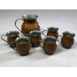Set of six brass and copper handled cups and a jug approx 16cm in height