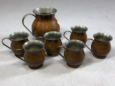 Set of six brass and copper handled cups and a jug approx 16cm in height