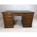 Twin pedestal leather-topped writing desk with brass handles, approx 140cm x 77cm x 77cm