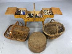 One wooden, extendable sewing box on legs, filled with haberdashery items, with a trio of baskets