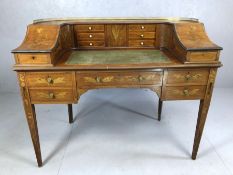 Antique inlaid writing desk with leather top and gallery containing multiple drawers, metal