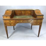 Antique inlaid writing desk with leather top and gallery containing multiple drawers, metal