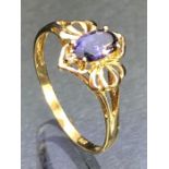 9ct Gold ring set with a faceted Amethyst flanked by two small diamonds and with pierced Gold