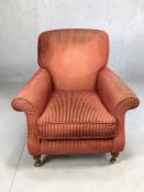 Single upholstered armchair on turned front legs and castors