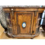 Ornate inlaid display cabinet with bowed glass frontage, porcelain floral centre decoration and