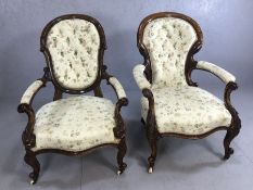 Pair of 'His and Hers' Victorian low upholstered walnut armchairs with carved detailing on