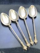 Four Silver spoons each with twisted handle and surmounted by a double faced eastern head. Marked