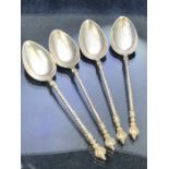 Four Silver spoons each with twisted handle and surmounted by a double faced eastern head. Marked