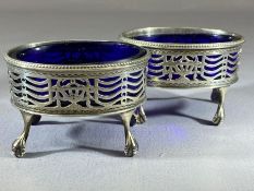 Pair of George III Oval Silver hallmarked salts with blue glass liners (A/F) on tall bird feet