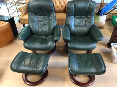 Pair of Ekornes reclining leather armchairs on wooden swivel bases with matching foot stools