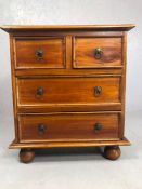 Small chest of four drawers with metal handles on bun feet, approx 70cm x 40cm x 80cm tall