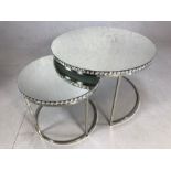 Nest of two mirror topped occasional tables on chrome bases, the largest approx 76cm in diameter