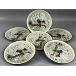Collection of six Oriental stoneware plates decorated with birds on a branch, surrounded by flowers,