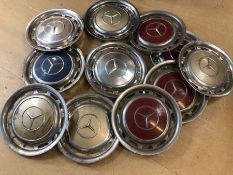 Collection of eleven Mercedes hubcaps, in multiple colours