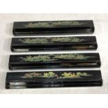 Four black lacquered oriental games holders, etched and painted with scenes of forests, mountains