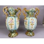 Pair of majolica twin handled urns, each approx 35cm tall