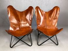 Pair of tan leather chairs on black metal frames