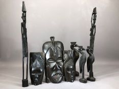 Collection of carved wooden tribal items to include masks and a set of three graduating birds (8)