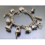 Solid silver charm bracelet with silver heart shaped lock and eleven charms