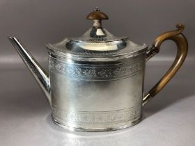 Silver teapot with embossed detailing and wooden handle and finial. Underside of lid has hallmarks