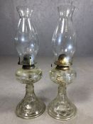 Pair of clear glass oil lamps, approx 47cm tall