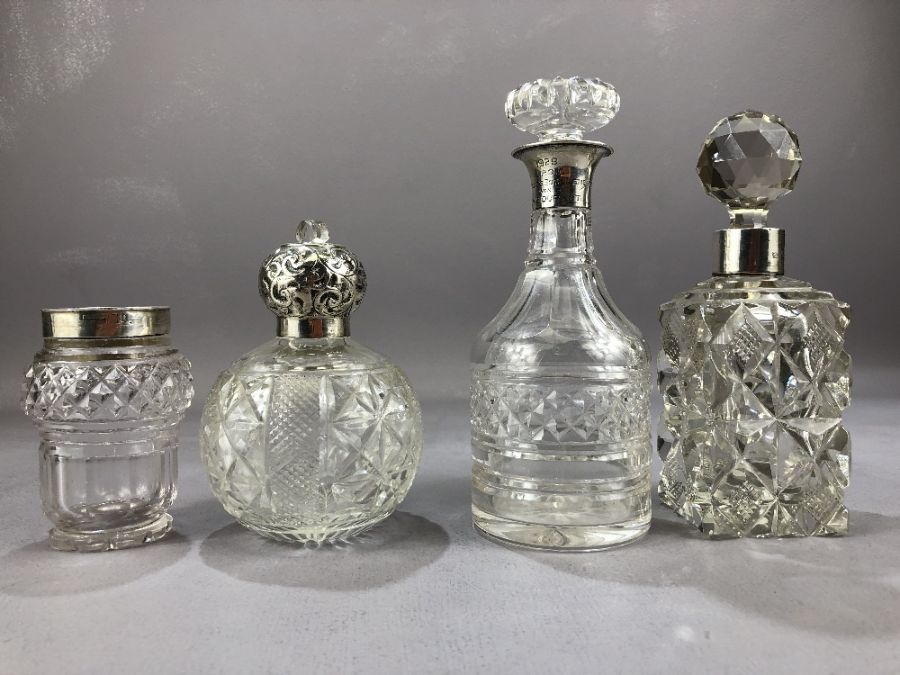 Collection of four cut glass and silver hallmarked collared bottles the tallest approx 18cm