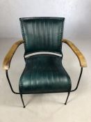 Single blue leather upholstered retro style chair on black metal frame with wooden arms