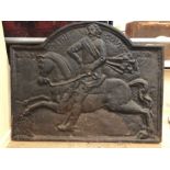 Cast iron fire back depicting a man riding a horse, approx 85cm x 67cm