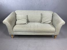 Two seater grey fabric sofa on turned pine legs with two matching cushions, approx 177cm x 83cm x