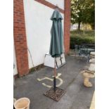 Wrought iron umbrella stand and green fabric parasol