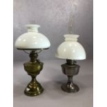 Two oil lamps, one by Aladdin, one brass, both with glass chimneys and shades, the tallest approx
