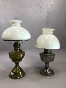 Two oil lamps, one by Aladdin, one brass, both with glass chimneys and shades, the tallest approx