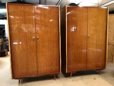 Mid Century high polish pair of two door wardrobes on splayed legs with gold handles, one fitted