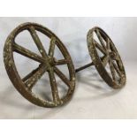 Pair of seven spoke vintage cast iron cartwheels with axels, approx 75cm in diameter