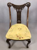 Antique carved wooden chair with curved supports and scroll detailing