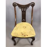 Antique carved wooden chair with curved supports and scroll detailing