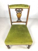 Antique low wooden and green velvet upholstered bedroom chair, on turned legs with original castors,