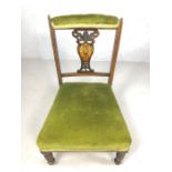 Antique low wooden and green velvet upholstered bedroom chair, on turned legs with original castors,