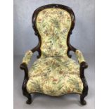 Heavily carved wooden framed low armchair, with floral fabric upholstery, approx 97cm tall