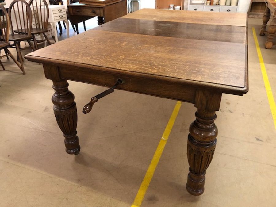 Extending dining table on baluster legs and castors, with winder, approx 182cm x 114cm (extended)