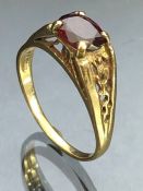 9ct Gold ring set with a faceted garnet on a raised gold setting size approx 'V'