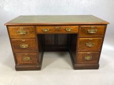 Twin pedestal leather-topped writing desk with brass fitments, approx 132cm x 61cm 77cm tall