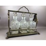 Metal tantalus with three cut glass decanters, approx 39cm in length (no key)