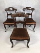 Three heavily carved dining chairs on scroll feet